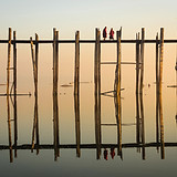 Reflejo de monjes cruzando un puente de