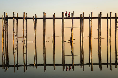 Reflejo de monjes cruzando un puente de