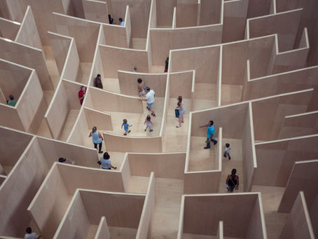 People wondering around a maze looking for the right path.