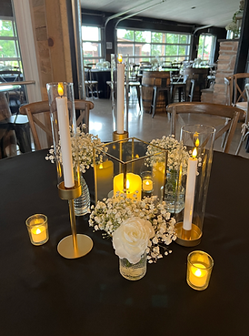 Elegant table centerpiece with candles, flowers, and glowing lights at event.
