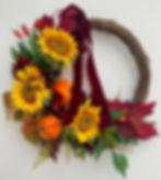 Front Spiced Autumn Bloom wreath with faux sunflowers, berries, leaves, ferns, velvet pumpkins, and dark red ribbon.