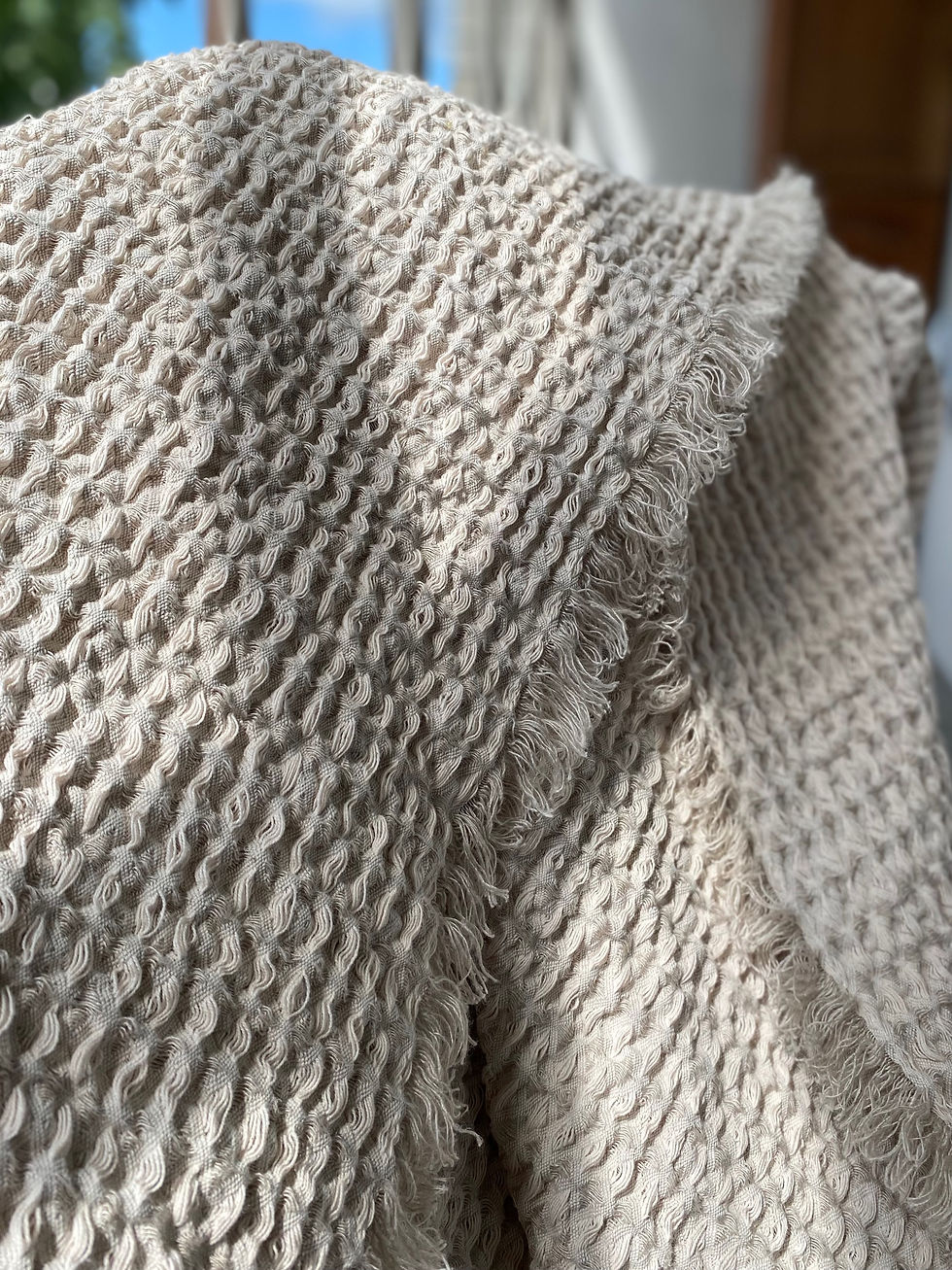 Photo of a linen blanket in natural grey. The blanket features soft, textured linen fabric in a muted grey shade, providing a cozy and elegant addition to any bedroom or living room.