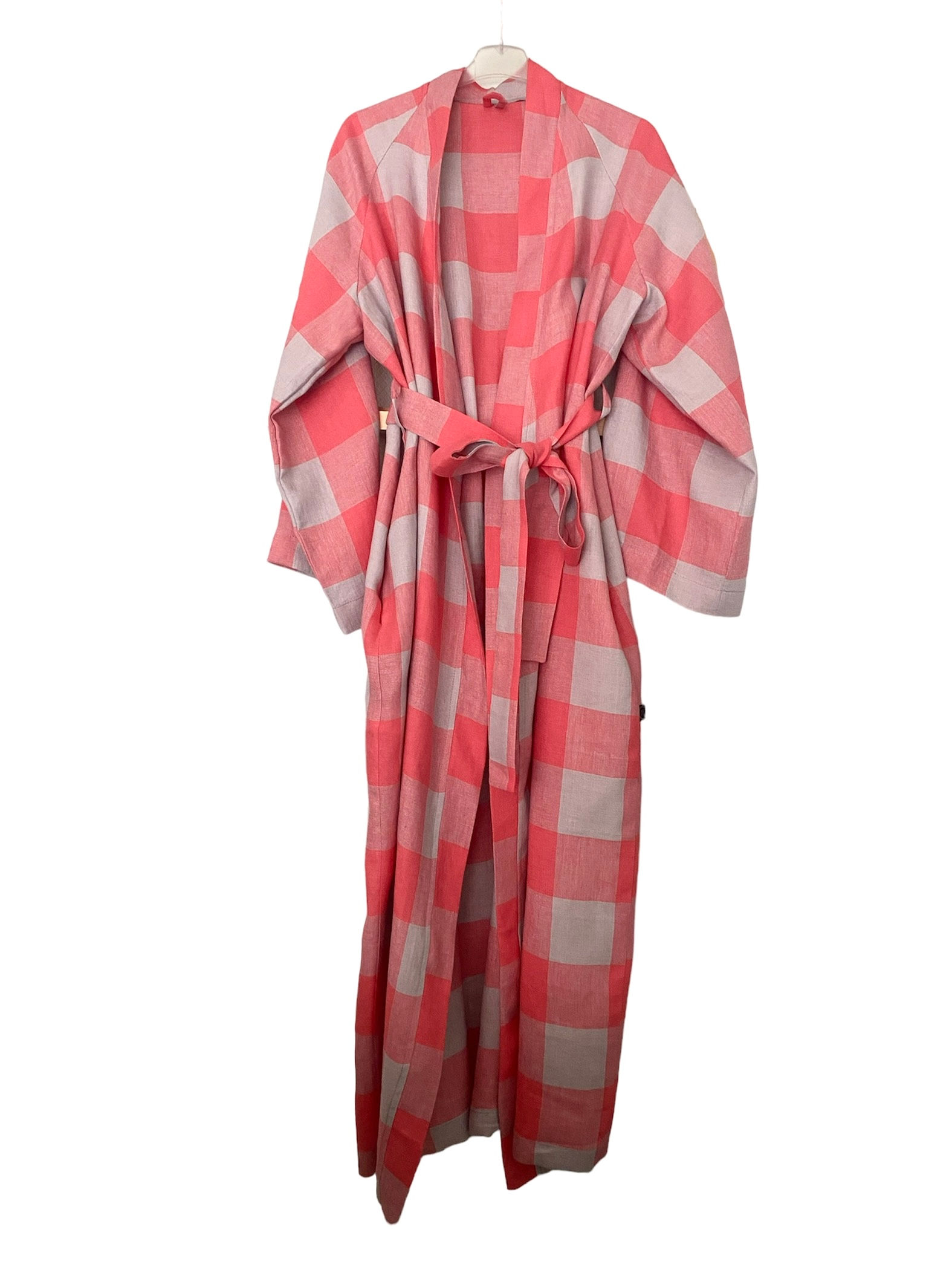 Photo of a pink checkered soft pure linen bathrobe. The robe features a gentle, breathable fabric with a classic checkered pattern, offering both comfort and style for relaxed moments at home.
