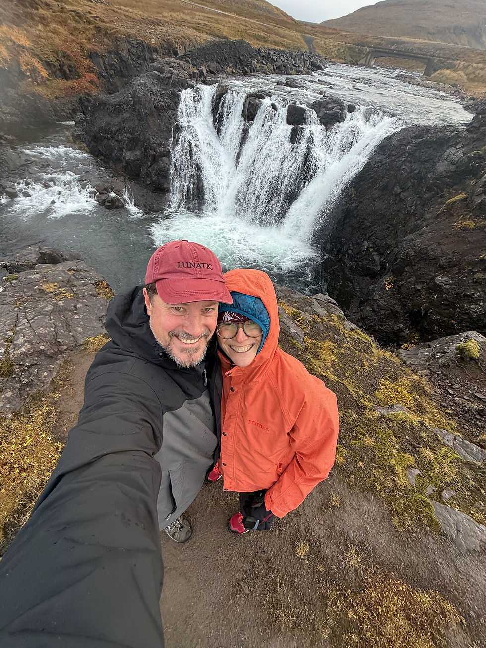 Carolyn and her husband in front of an Iceland waterfall.