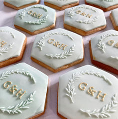 Sage green cookies embossed with G & H in a wreath