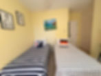 Twin beds in a guest room with mellow yellow paint