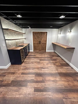 Finished basement with recessed lights and wall sconces