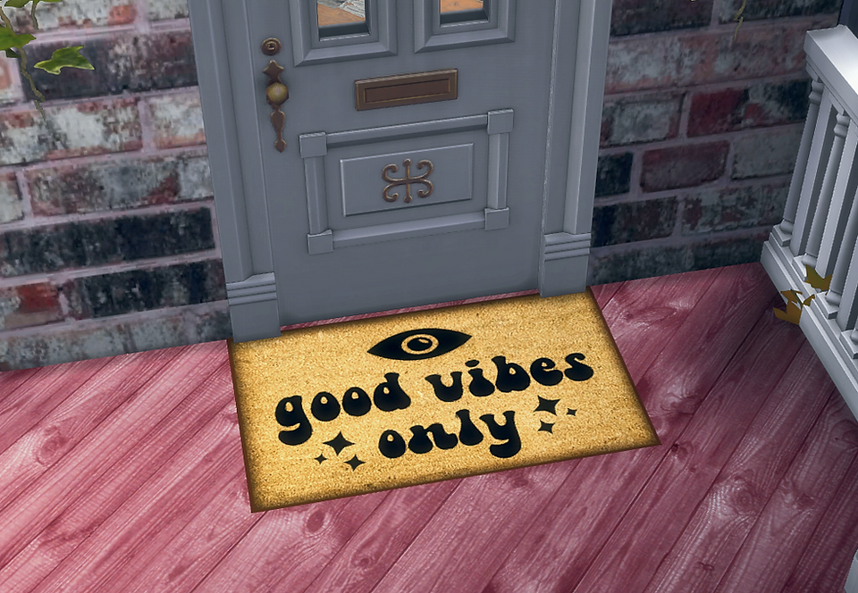 CarolaSims' Evil Eye Doormat with a decorative eye, text "Good Vibes Only" in black, on a red floor. Background features a gray door.