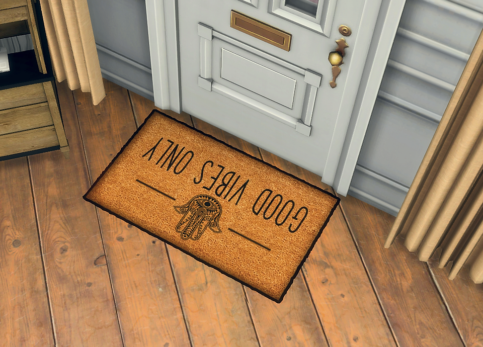 CarolaSims' Evil Eye Doormat with a decorative hamsa hand and an eye, text "Good Vibes only" in black, in an entryway. Background features a white door.