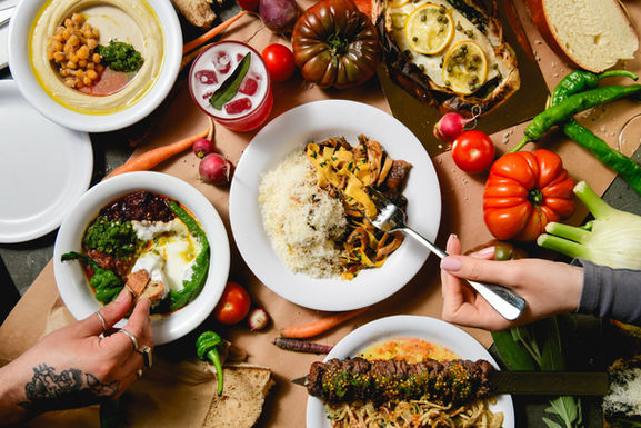 port said dishes like pasta hummus and skewers on a full table