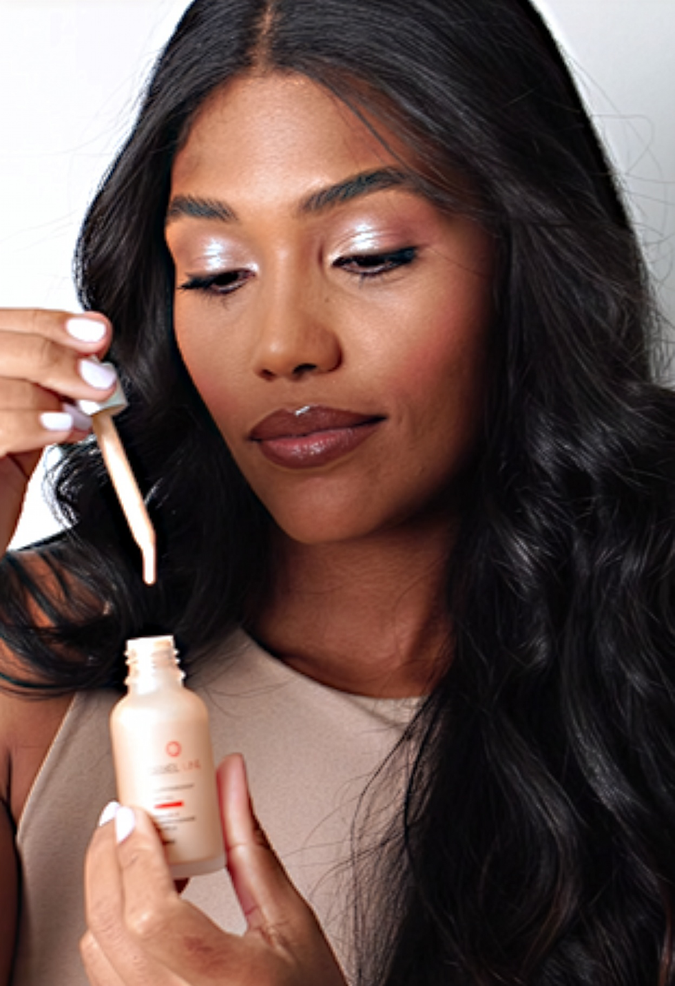 Modelo segurando um produto cosmético.