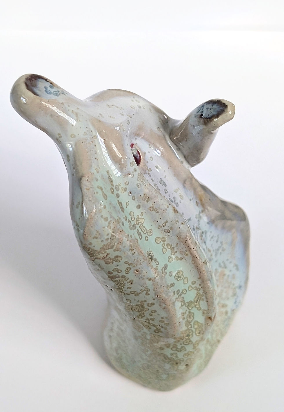 Ceramic sculpture "With Open Hands" shows a person leaning backwards with an open hand as if waiting to receive.