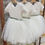 Thumbnail: A handmade ivory white lace  tutu dress with a V pearl button back. It features a soft ivory white tulle skirt that falls knee length and a sage ribbon bow sash. The perfect flower girl, birthday dress or Christmas party dress