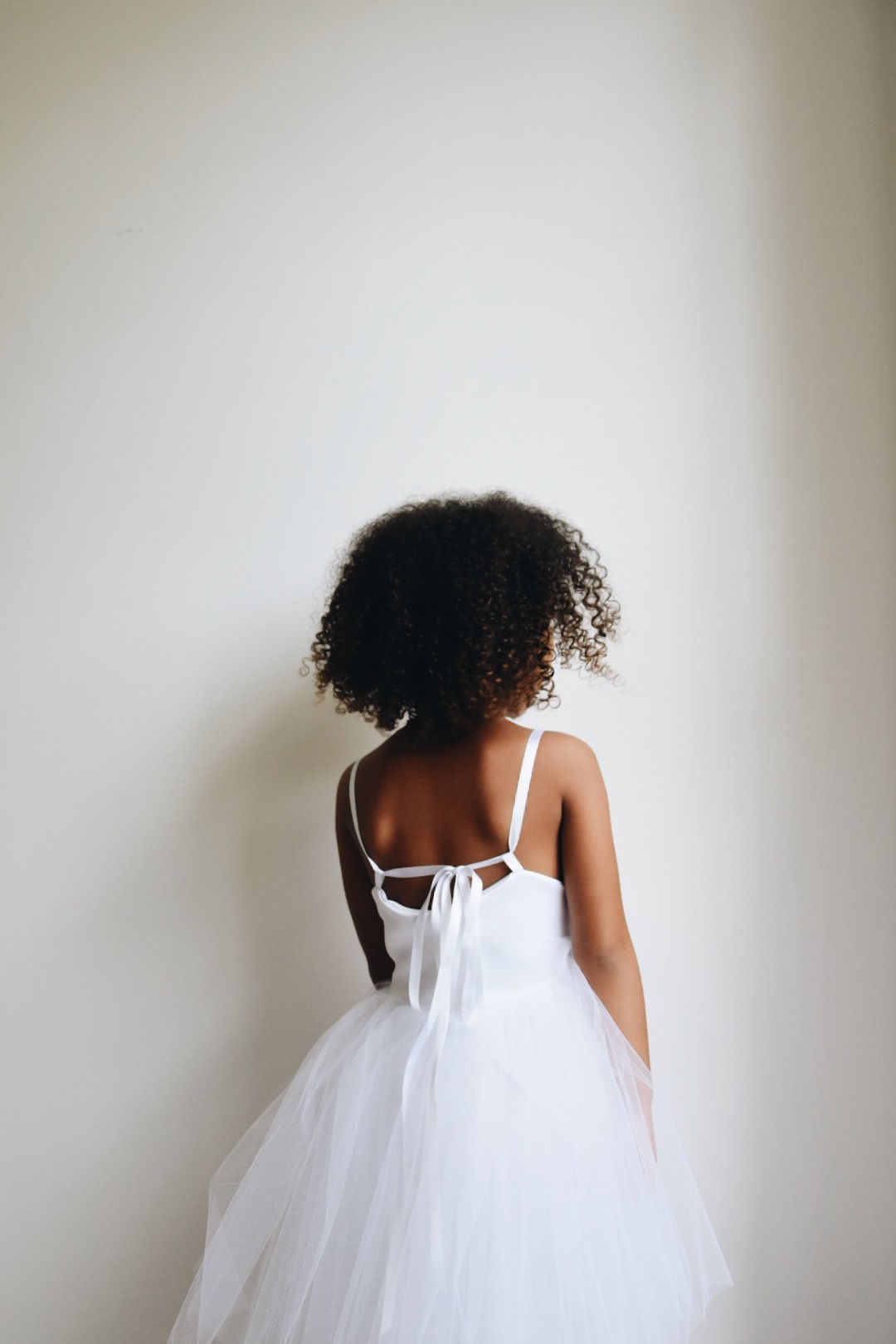 A handmade ivory white duchess satin tutu dress which features a cute ribbon tie strap. The soft ivory white tutu skirt is knee length. The perfect flower girl, birthday dress or Christmas party dress. Perfect Holy Communion dress