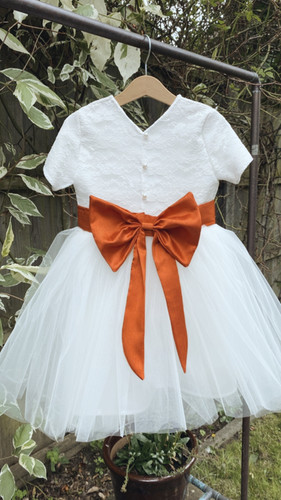 Lace Pearl button back with a burnt orange bow sash flower girl