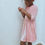 Thumbnail: A handmade pink velvet skater dress with long sleeves. The dress falls just below the knee. The perfect flower girl, birthday dress or Christmas party dress