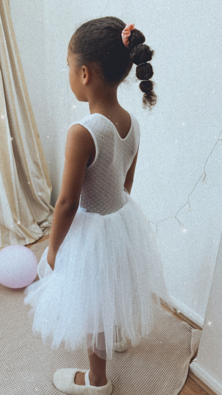 Thumbnail: A handmade white ivory tutu dress which has a dottie lace top and a sheer dottie lace back. It features a soft ivory white tulle skirt that falls just below the knee. The perfect flower girl, birthday dress or Christmas party dress