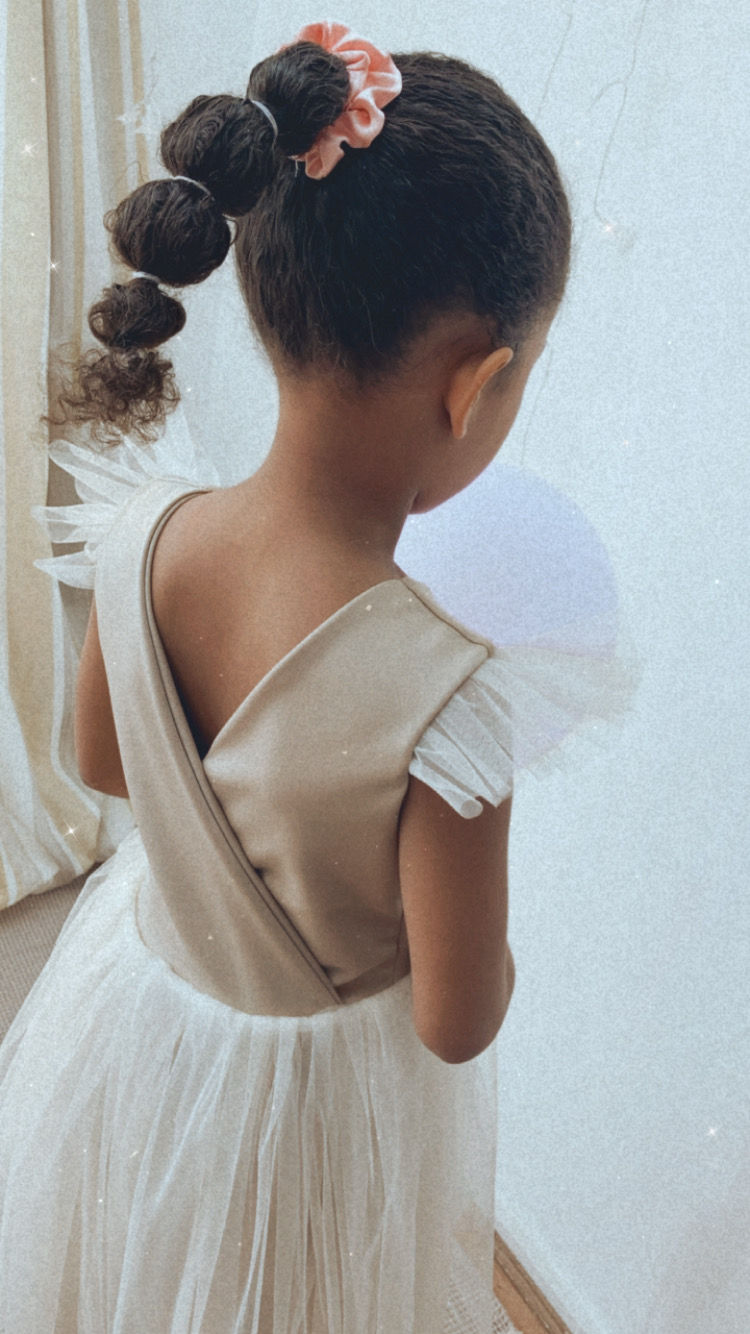 A handmade beige champagne tutu dress with a cross over back and tulle frill sleeves. It features a soft beige tutu skirt that falls just below the knee. The perfect flower girl, birthday dress or Christmas party dress