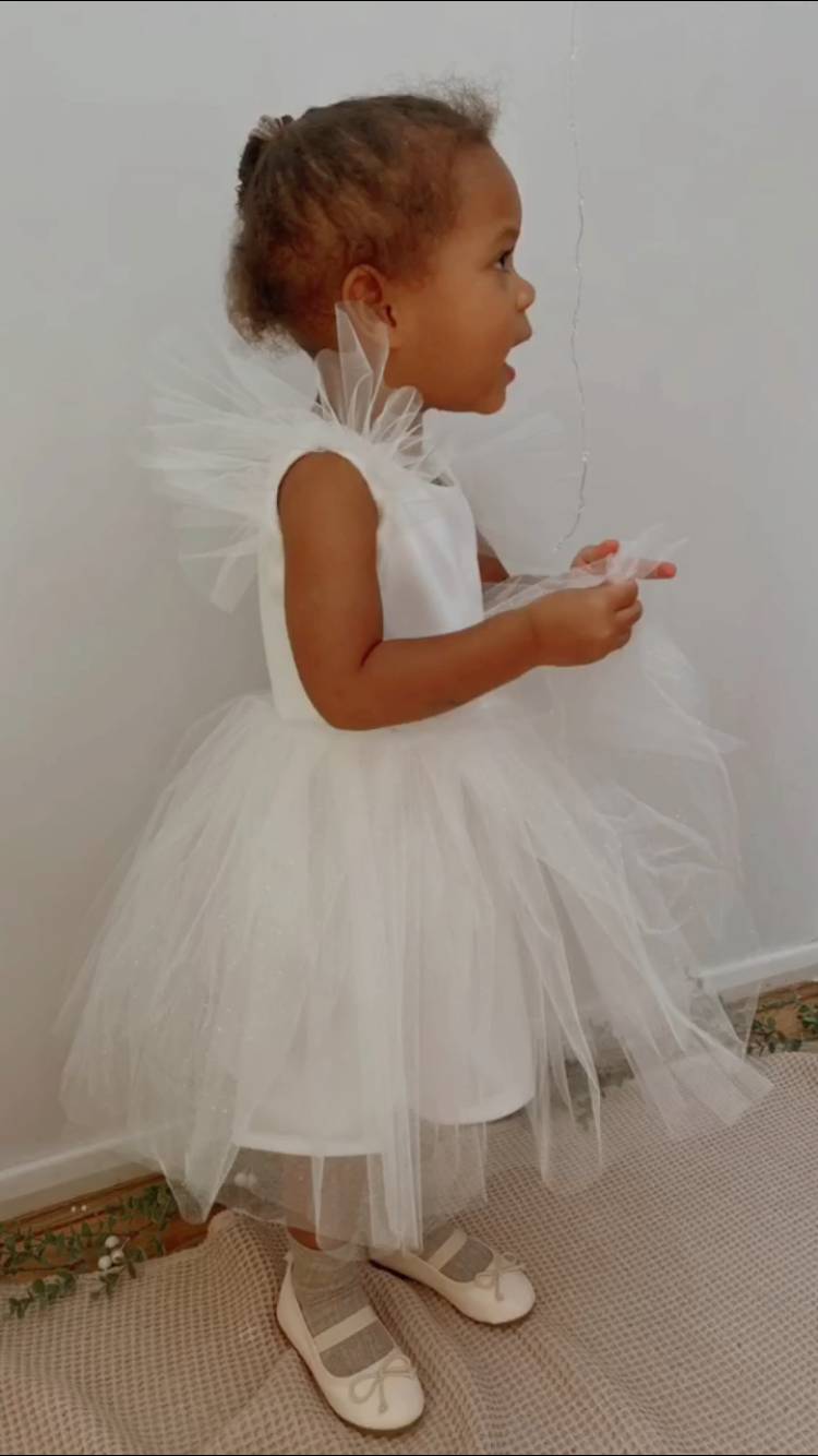 Thumbnail: A handmade sparkly ivory white velvet tutu dress with soft tulle frill sleeves. It features a sparkly tulle skirt that falls knee length. The perfect flower girl, birthday dress or Christmas party dress