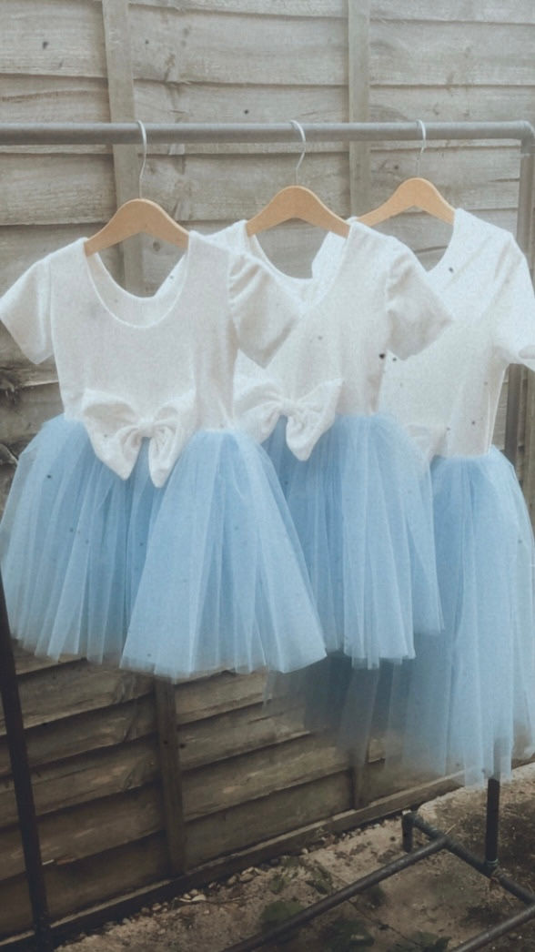 Thumbnail: A handmade ivory white velvet tutu dress with cap sleeves and a large velvet bow. It features a soft  pale blue tulle skirt that falls knee length. The perfect flower girl or birthday dress