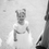 Thumbnail: A handmade ivory white duchess satin tutu dress with tulle puff cap sleeves and a soft tulle knee length skirt flower girl dress. It features a cross over style back with a satin ribbon bow sash.