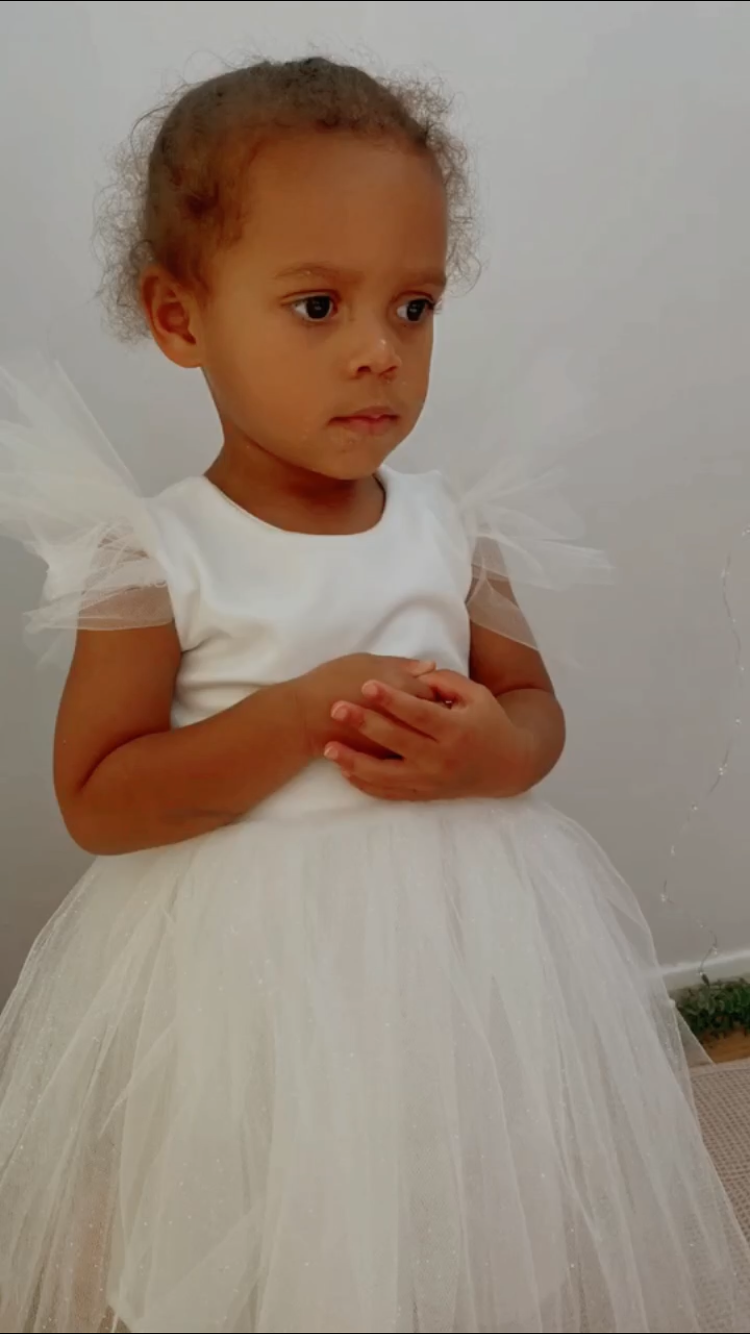 A handmade sparkly ivory white velvet tutu dress with soft tulle frill sleeves. It features a sparkly tulle skirt that falls knee length. The perfect flower girl, birthday dress or Christmas party dress