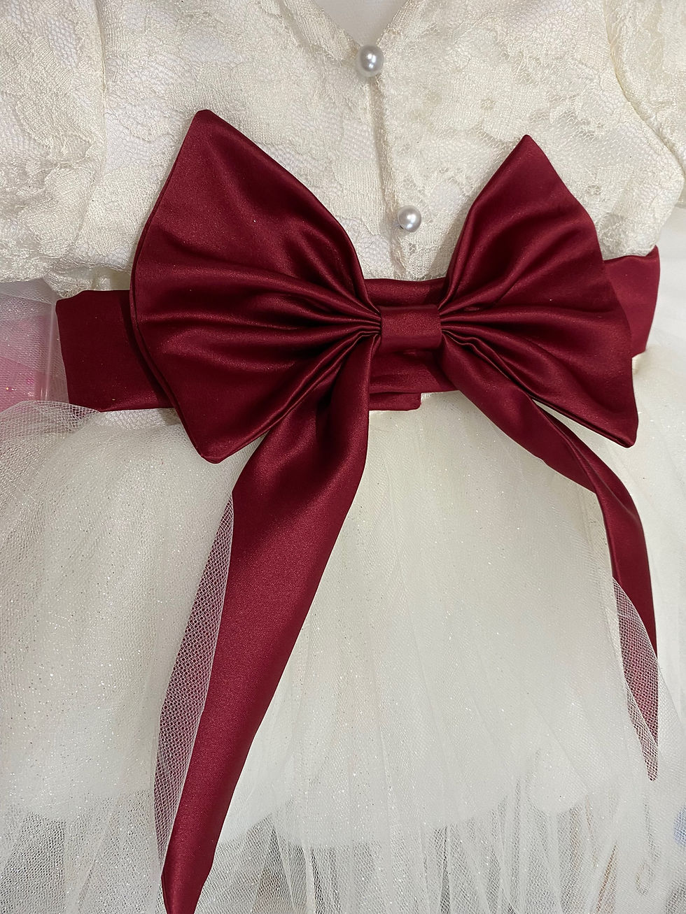 Thumbnail: A handmade cap sleeve lace ivory white tutu dress with a V pearl button back and a large wine duchess satin bow sash. It features a soft ivory white tulle skirt that falls to the knee the perfect flower girl or birthday dress