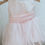 Thumbnail: A handmade pale pink tutu dress with a heart cut out back and a large duchess satin bow sash. It features a soft pink tulle skirt that falls to the knee the perfect flower girl or birthday dress