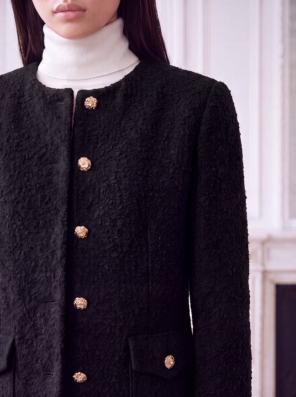 Thumbnail: Detailaufnahme Schwarzer Damen Blazer mit goldfarbenen Schmuckknöpfen, Rundhalsausschnitt und Pattentaschen.