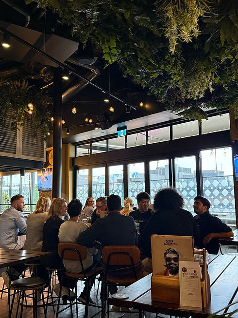 A full table of friends enjoying great food and drinks at John Barleycorn’s Taphouse Newmarket, inviting you to book your spot at this vibrant Newmarket rooftop pub.