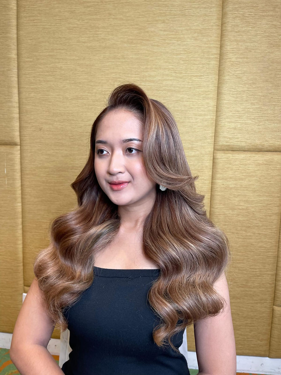 Woman with voluminous wavy brown hair, smiling