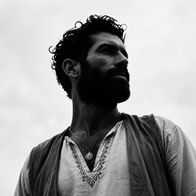 Black-and-white portrait of Andrew Meraldson looking into the distance.