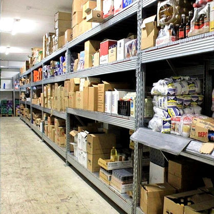 Sturdy, industrial grade shelving units stocked with a variety of boxed products and supplies in a commercial storage space.