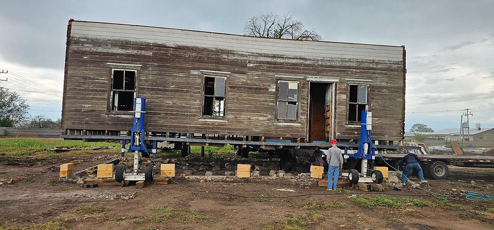 Mit Hebevorrichtungen wird das komplette Erdgeschoss angehoben. Unter dem Haus sind bereits Träger und Unterlagen für die Aufnahme auf den Tieflader zu erkennen