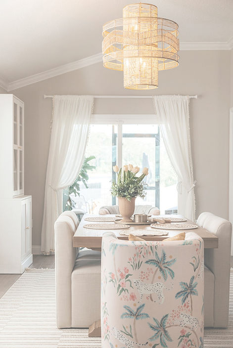 Dining room designed by Zen Reno & Design in St. Augustine, FL, featuring whimsical patterned dining chairs, a statement woven chandelier, custom furnishings, and soft color accents that bring character and personality to the space.