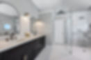Primary bathroom renovation in Jacksonville Golf & Country Club designed by Zen Reno & Design with a dark double vanity, marble surfaces, arched mirrors, black fixtures, and frameless shower glass.
