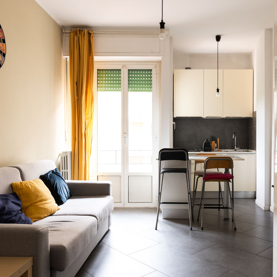 soggiorno con cucina a vista e finestra balcone