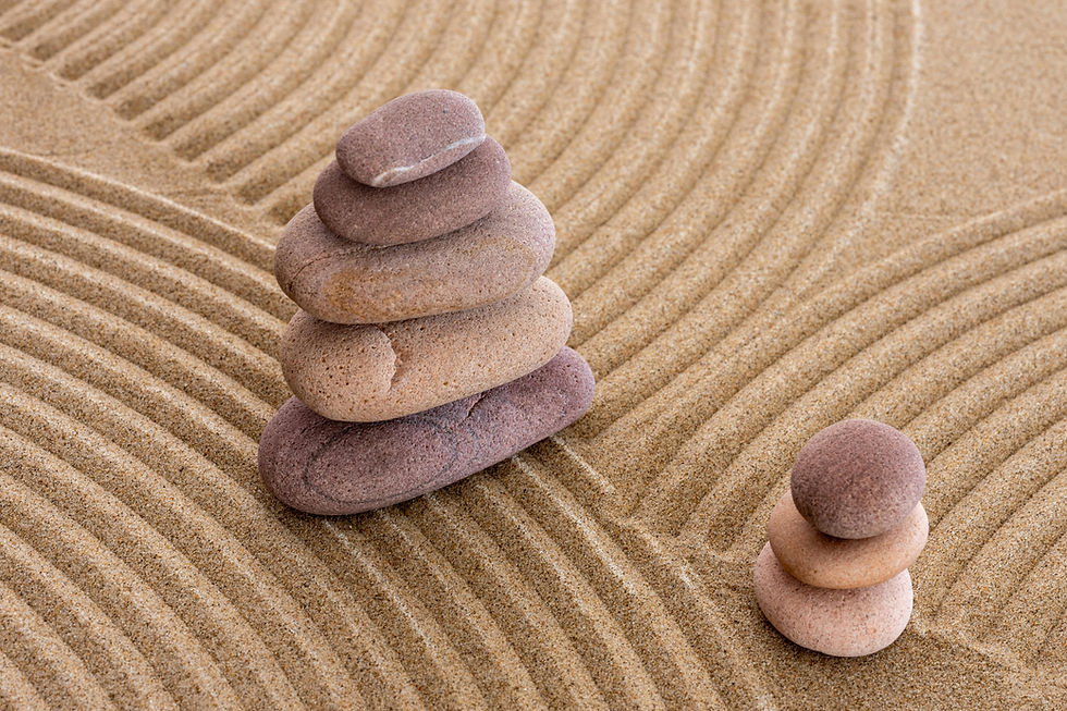 Stacked zen stones on raked sand at Wisdom Infinita.