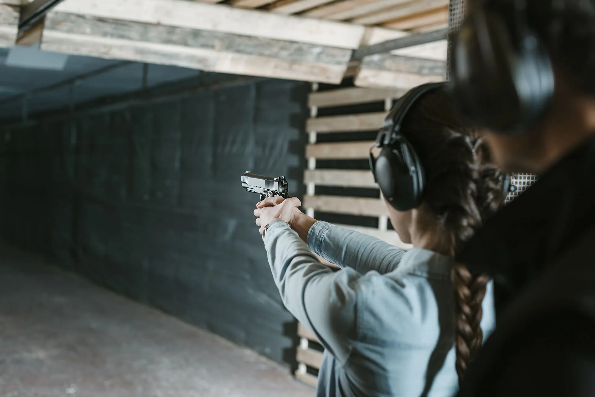 rear-view-of-girl-shooting-with-gun-in-shooting-ga-42ZKBTB-2.webp