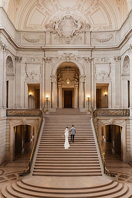 Bride and groom walking up the stairs at San Francisco City Hall