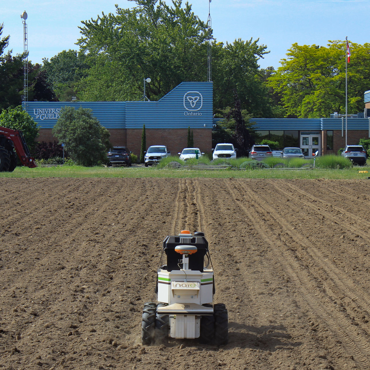 The Naio Oz robot pulls a wizard seeder through a field in front of the University of Guelph Simcoe Research Station