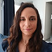 Portrait d'une femme aux longs cheveux bruns ondulés.