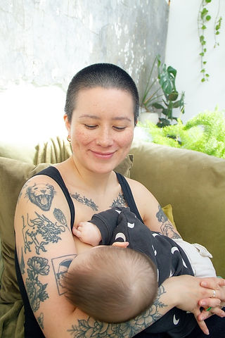 A monocrome photograph of a baby asleep on the shoulder of their parent, it is a baby photoshoot from empowerment and confidence photographer HeardinLondon