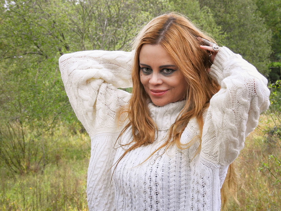 Sofie in the woodlands wearing a white jumper.  It is a portrait photograph taken by empowerment, self-esteem and confidence photographer HeardinLondon.
