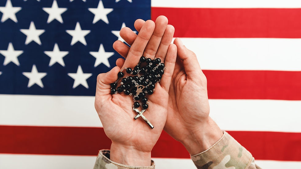 man in camo holding rosary with American flag in background