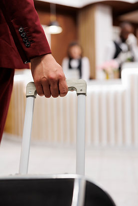 entrepreneur-with-baggage-enters-hotel-reception-front-desk-waiting-relax-after-travelling