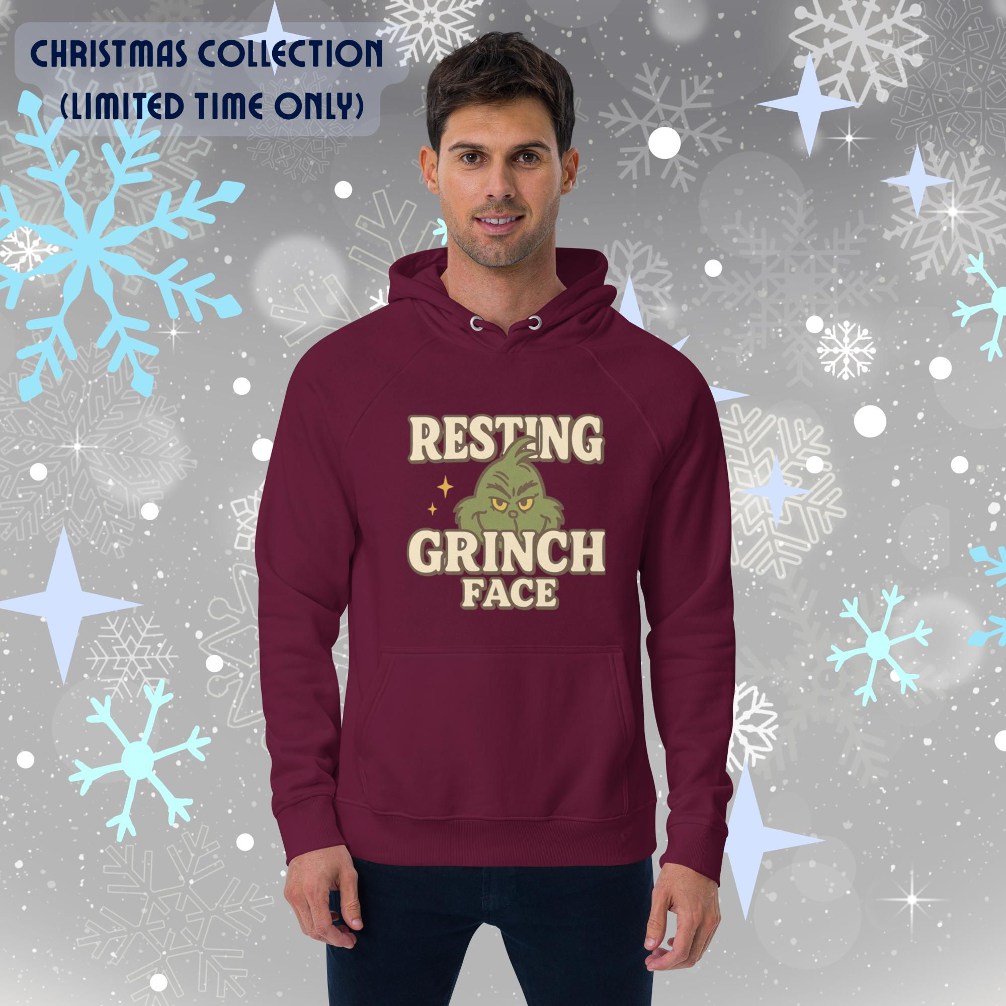 Resting Grinch Face design on a soft unisex eco raglan hoodie with organic materials and cozy brushed lining.