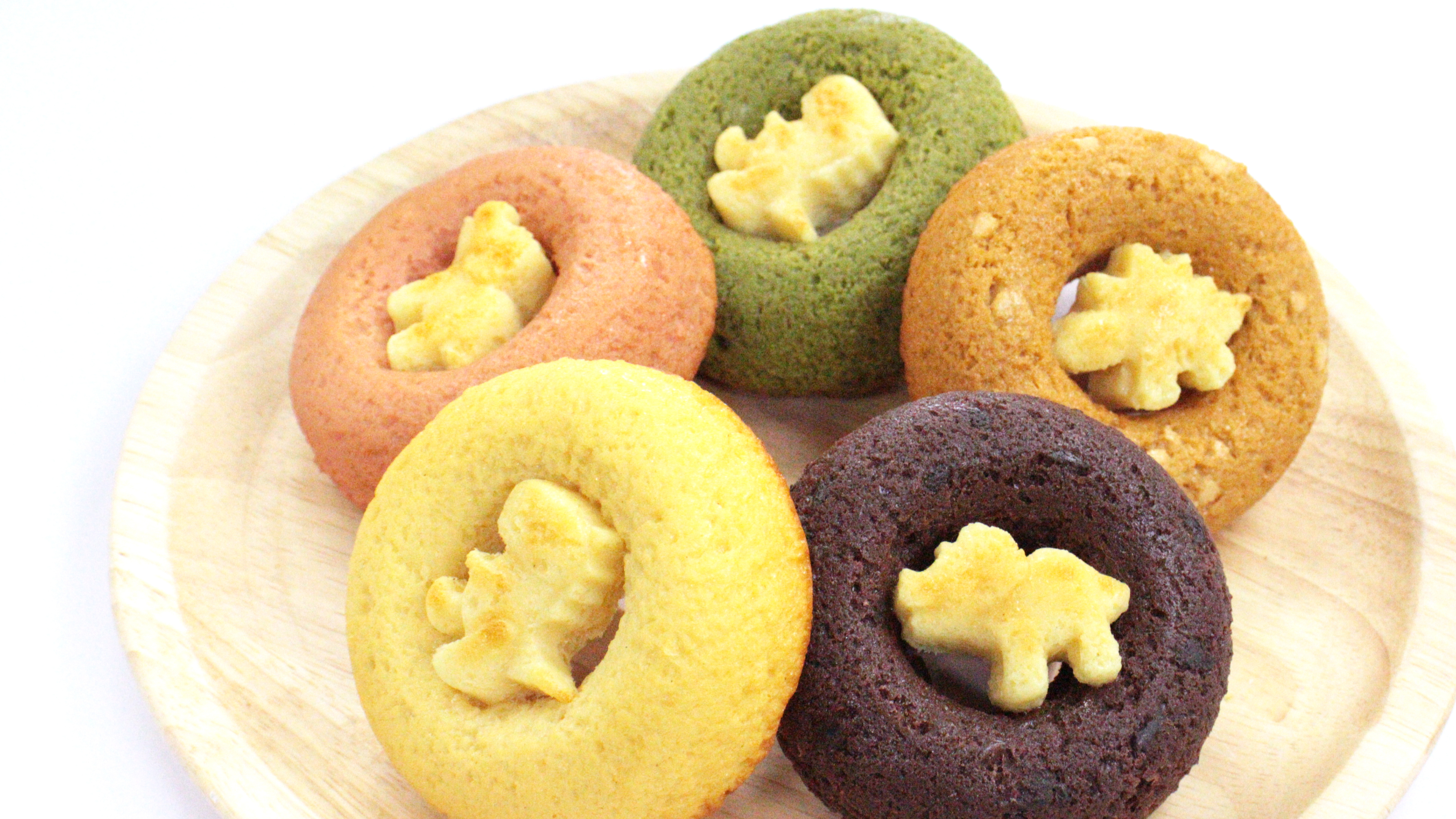 恐竜があしらわれたカラフルな焼きドーナッツです