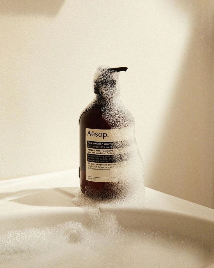 Soap bottle on bath tub edge with foam