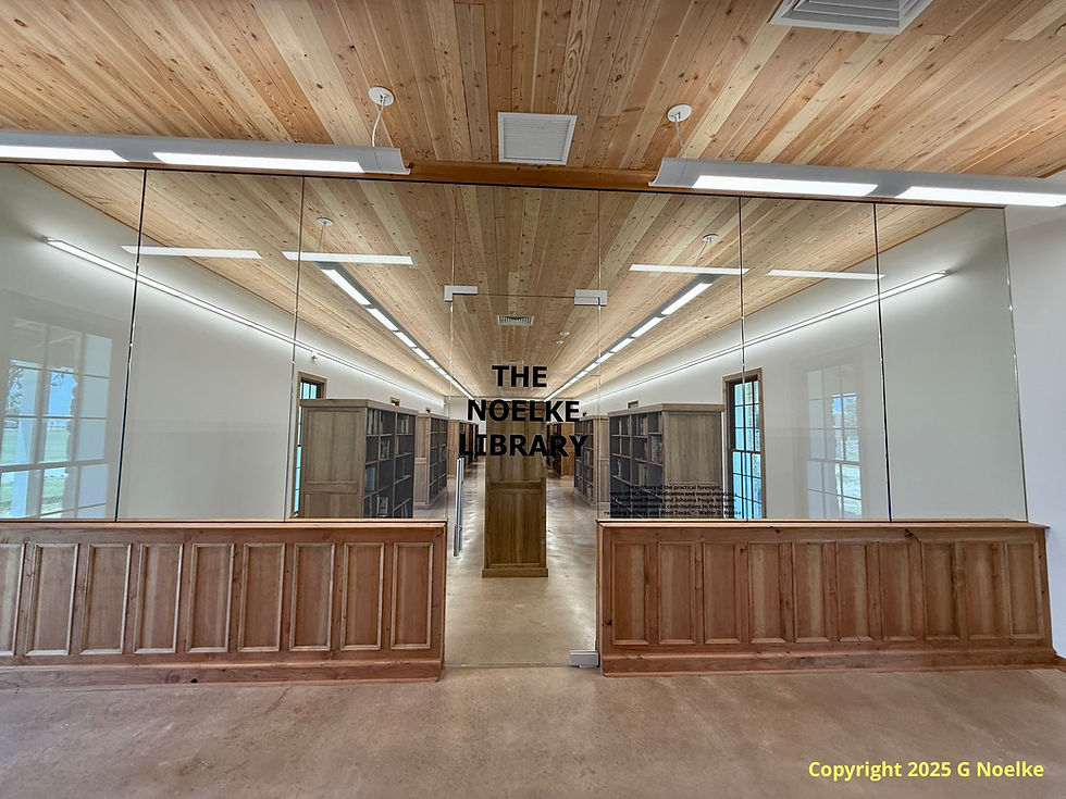 Photo of a long room with book shelves and a glass wall and a door that reads Noelke Library